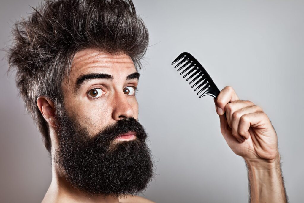 Homme à la barbe épaisse et ébouriffée tenant un peigne à barbe