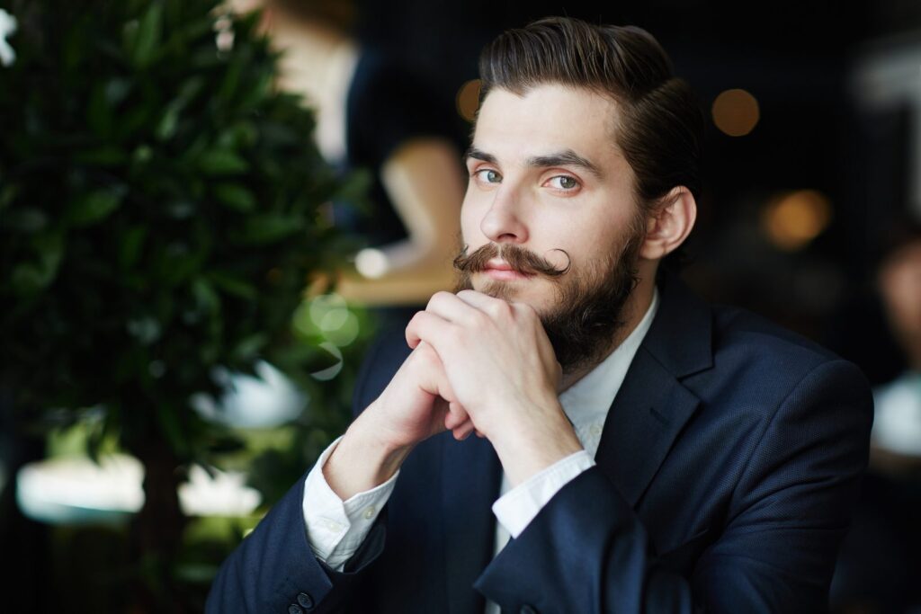Homme en costume portant une barbe courte et nette de quelques millimètres